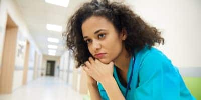 stressed nurse sitting in hallway