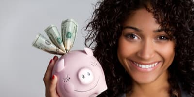 African-American woman holding piggy bank